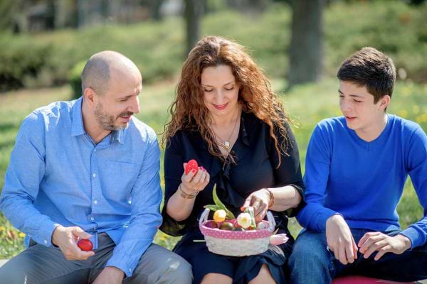 Famille partageant des œufs de Pâques dans un parc.