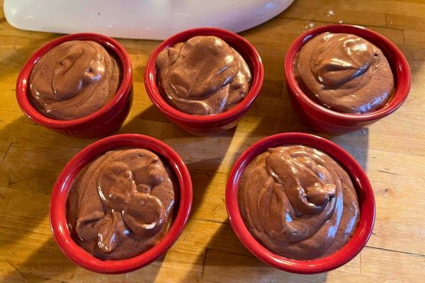 Mousses au chocolat vegan dans des ramequins rouges.