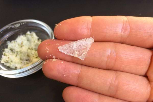 Cristal de sel tenu dans une main, montrant sa texture pour des rituels.