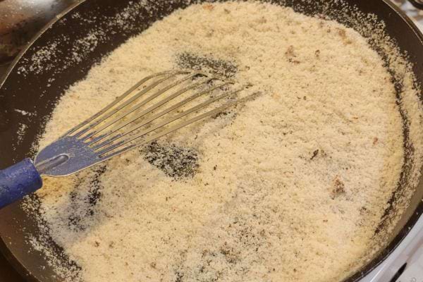 Gros sel chauffé dans une poêle avec un fouet bleu, prêt pour le rituel.