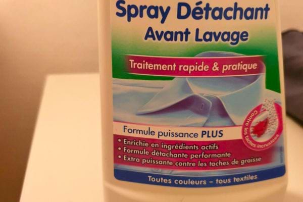 Bouteille de spray détachant avec étiquette décrivant ses utilisations.