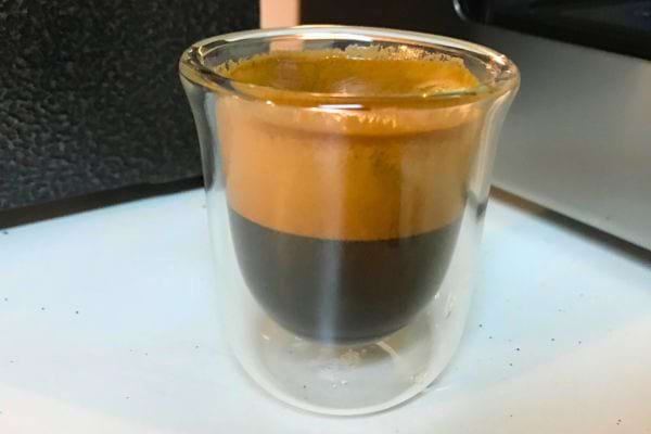 Tasse de café espresso montrant des couches de crème et de café.