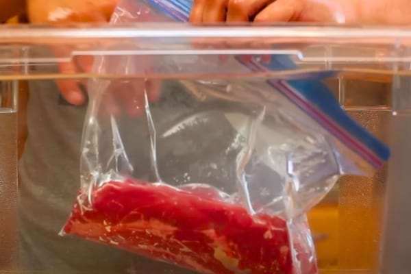 De la viande dans un sac plongée sous l'eau pour la mettre sous vide