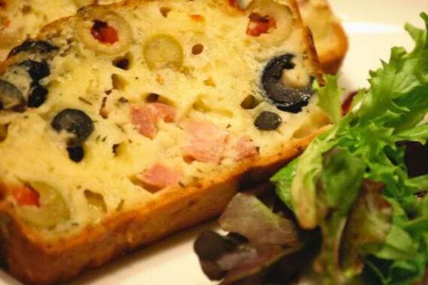 Cake aux olives et jambon, truffé d'ingrédients robustes, accompagné d'une salade légère.