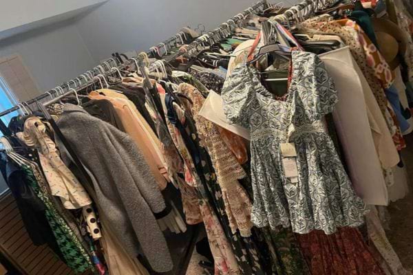 Magasin avec cintres de vêtements divers.