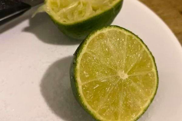 Citron vert coupé sur assiette; citron vert partiellement coupé sur essuie-tout.