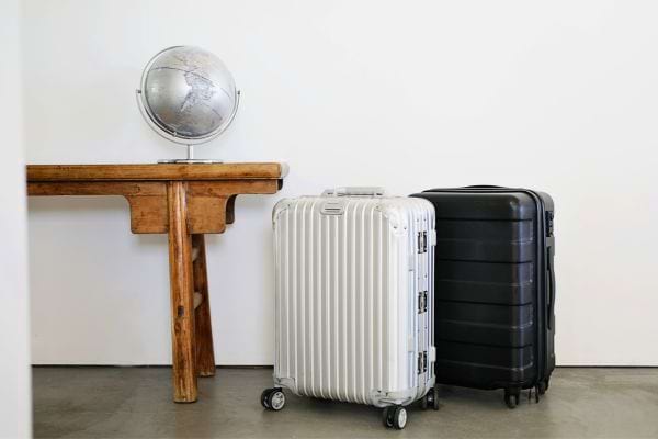 Deux valises près d'un globe et d'un bureau en bois.