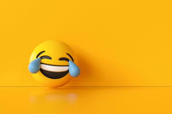 Emoji jaune riant aux larmes sur fond jaune.