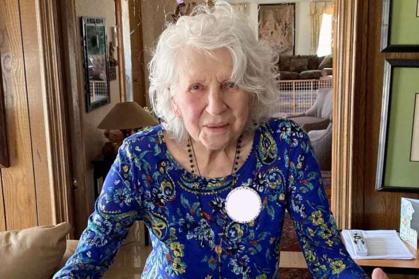 Femme âgée en robe bleue ornée.