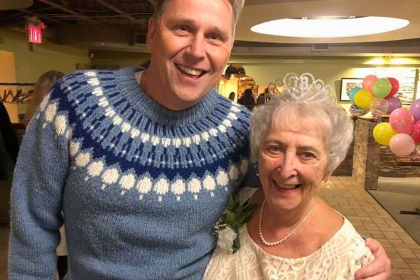 Homme et femme âgée souriants en fête.