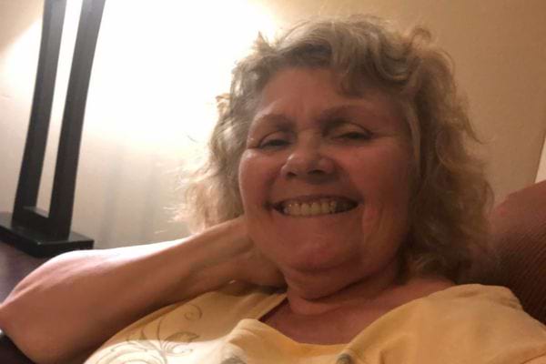 Femme âgée riant confortablement.