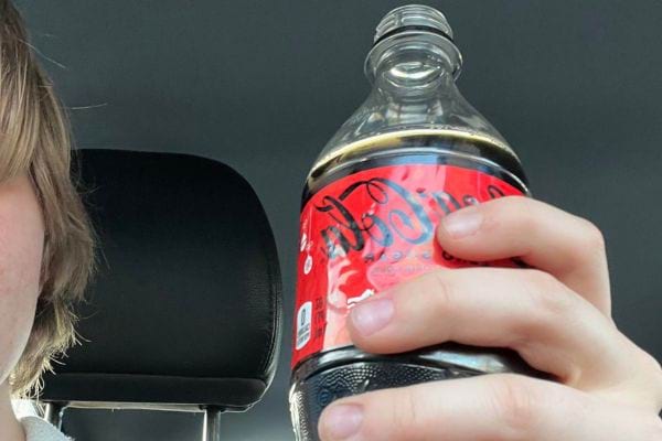 Personne tenant Coca-Cola.