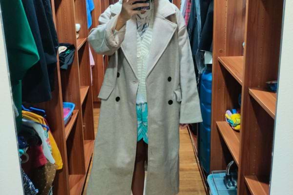 Manteau long beige dans un placard.