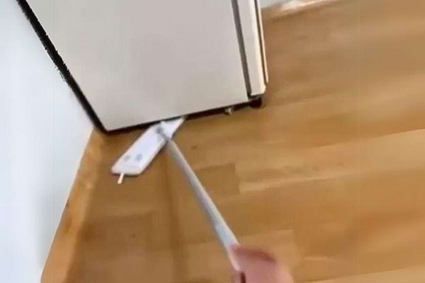 un balai plat pour nettoyer sous le réfrigérateur