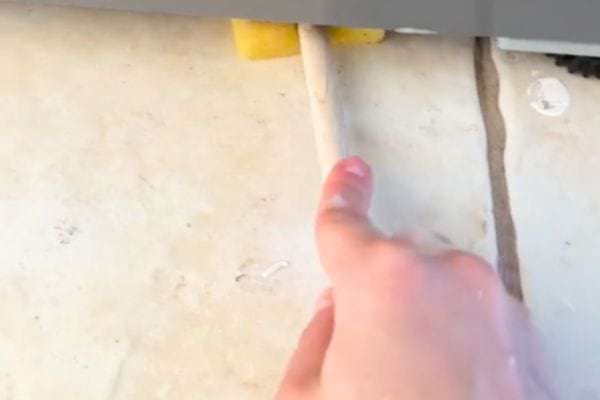 une cuillère en bois et une éponge pour laver sous le frigo