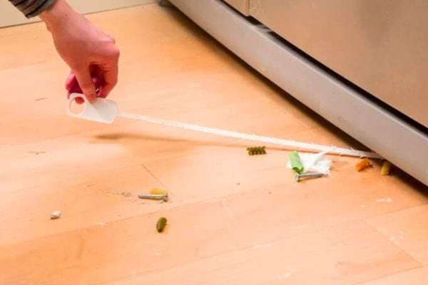 un furet en plastique pour nettoyer sous le réfrigérateur