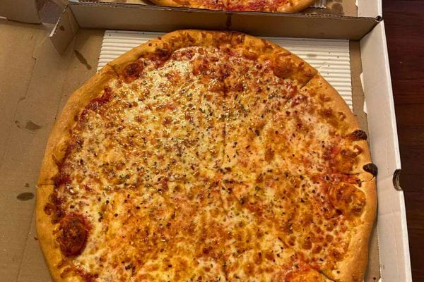 Pizza mozzarella entière dans une boîte.