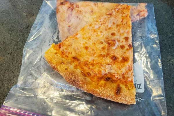 Morceau de pizza mozzarella dans un sac en plastique.