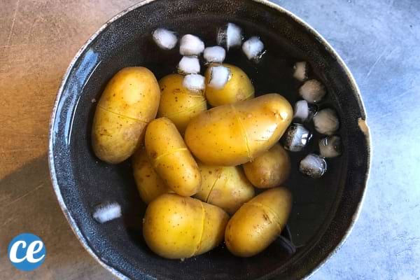 Une casserole remplie d'eau avec des pommes de terre épluchées