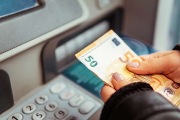 Une personne qui a retirer de l'argent au distributeur grâce à une carte de retrait unique