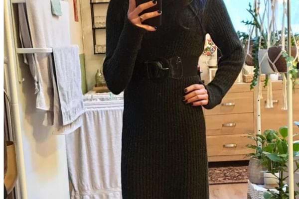 Femme en robe tricotée noire, miroir.