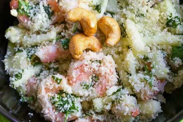 Salade de crevettes avec ananas et noix de cajou, garnie de fromage.
