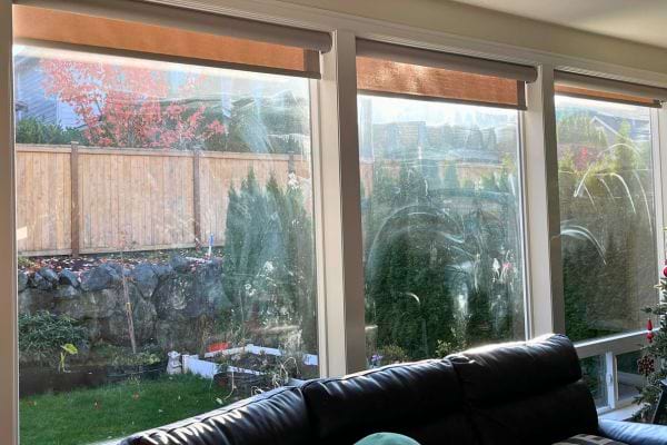 Salon lumineux avec vue sur un jardin verdoyant.