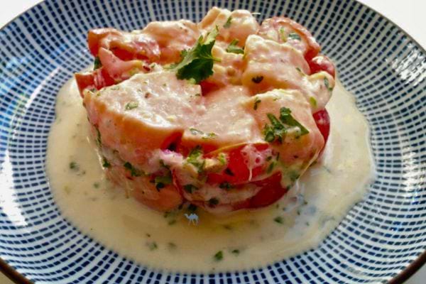 Tartare de saumon, servi avec une sauce crémeuse et garni de fines herbes