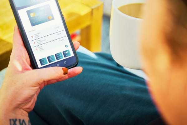 Une personne qui utilise son application bancaire pour faire un retrait