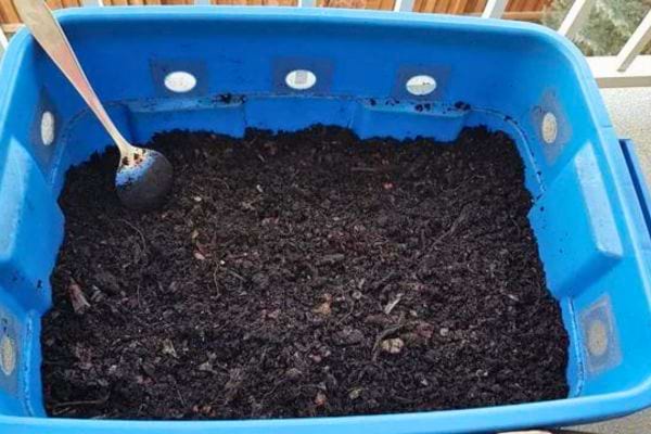 Bac bleu de compostage avec cuillère.