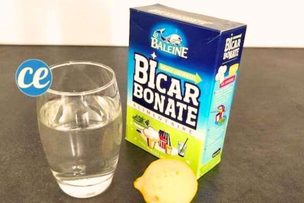 un verre d'eau avec du bicarbonate de soude et un citron