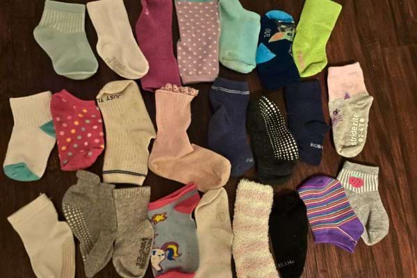 Chaussettes colorées dépareillées d'enfants sur un sol en bois.