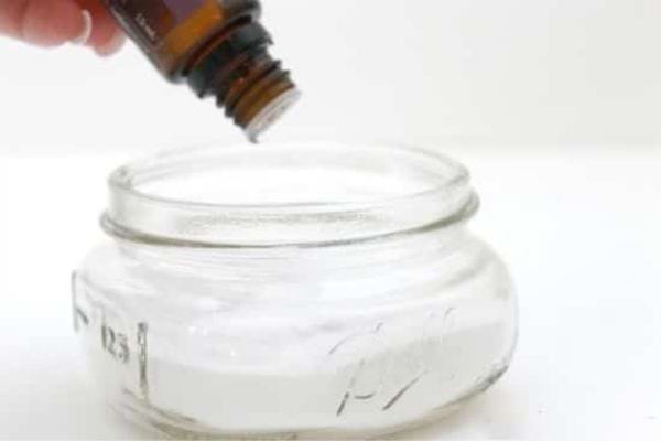 un pot avec du bicarbonate et de l'huile essentielle