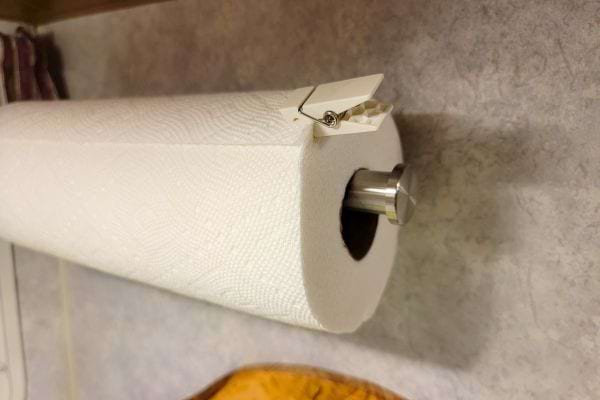 un rouleau de papier essuie tout sur un distributeur d'essuie tout avec une épingle