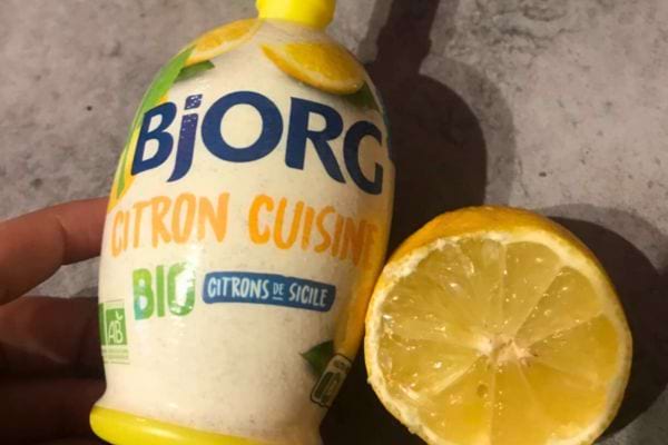 Bouteille de jus de citron Bjorg avec demi-citron.