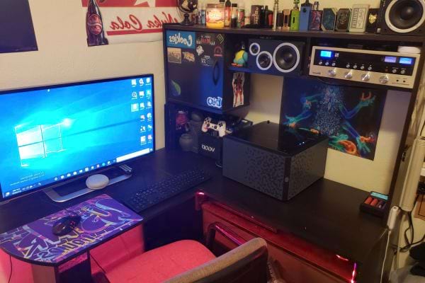 Setup de bureau avec un grand écran, clavier, souris et décoration.