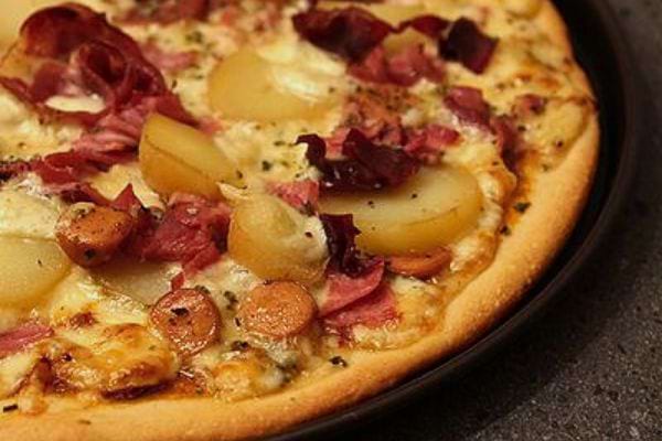 Pizza au fromage avec charcuterie et pommes de terre.