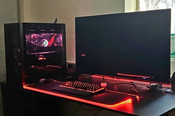 Station de jeu avec éclairage rouge, clavier, et grande tour PC.