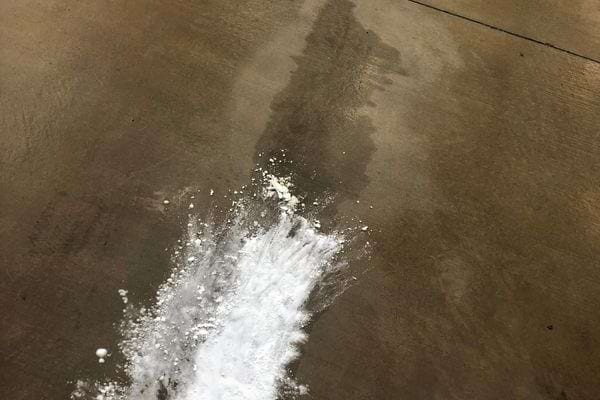 Bicarbonate de soude saupoudré sur une tache d'huile.