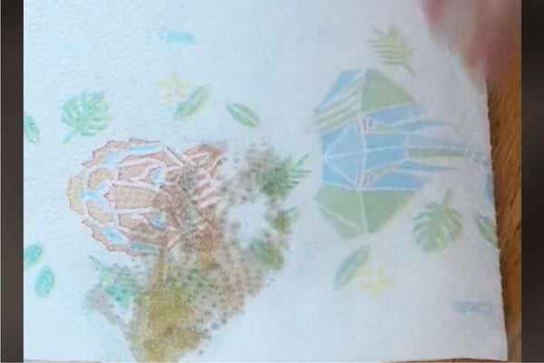 Essuie-tout absorbant une tache d'huile.