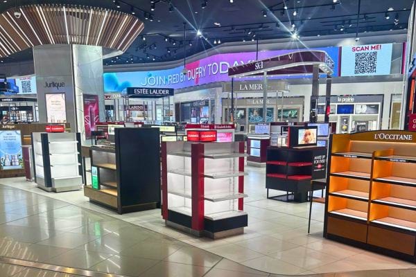 Étals vides de cosmétiques dans un Duty Free.