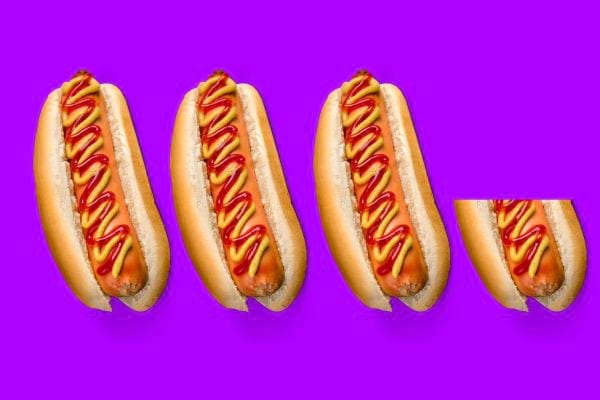 Quatre hot-dogs avec ketchup et moutarde.
