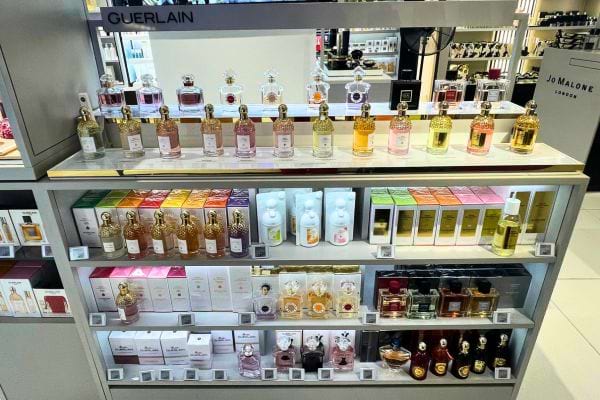 Présentation soignée de parfums Guerlain dans un Duty Free.