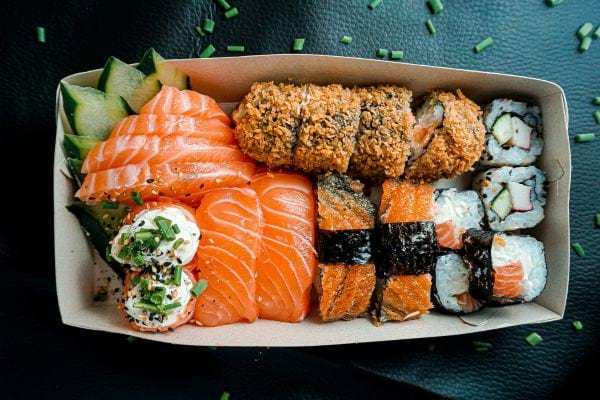 Plateau de sushi avec saumon et makis.