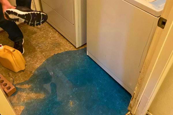 Lessive renversée sur le sol près d'une machine à laver.