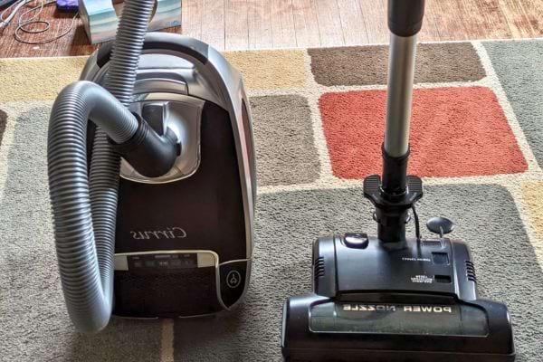 Aspirateur prêt pour nettoyer un tapis.