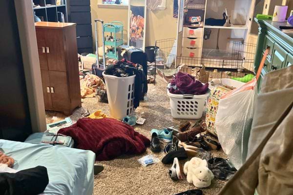 Chambre en désordre avec des vêtements au sol.