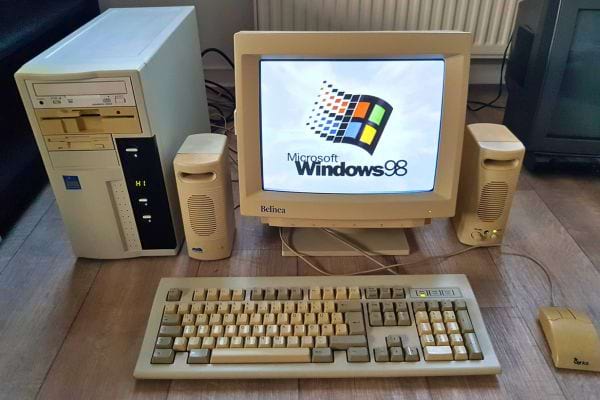 Ordinateur Windows 98 avec écran CRT beige et clavier mécanique.