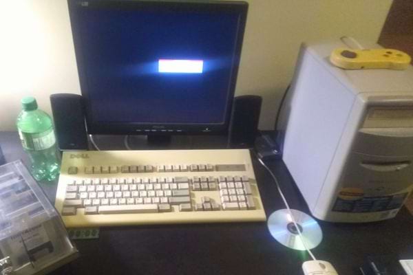 Écran plat moderne avec clavier rétro et unité centrale blanche.