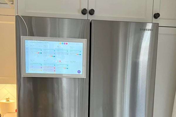 Frigo en acier inoxydable avec un écran intégré.